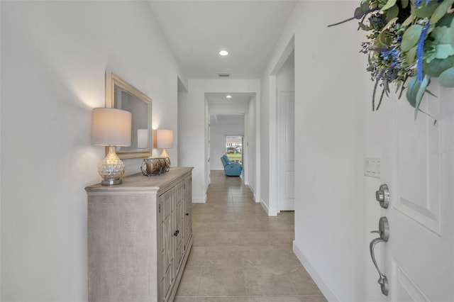 hall with recessed lighting, visible vents, and baseboards