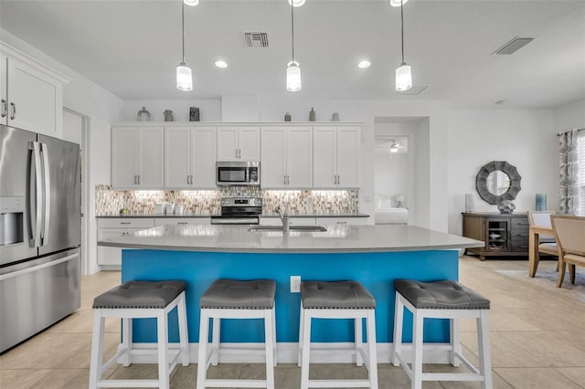 kitchen featuring appliances with stainless steel finishes, backsplash, a sink, and visible vents