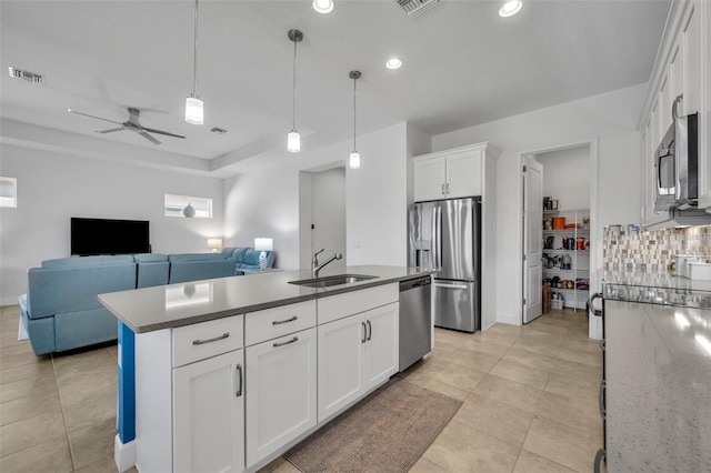 kitchen with tasteful backsplash, visible vents, white cabinets, appliances with stainless steel finishes, and a sink