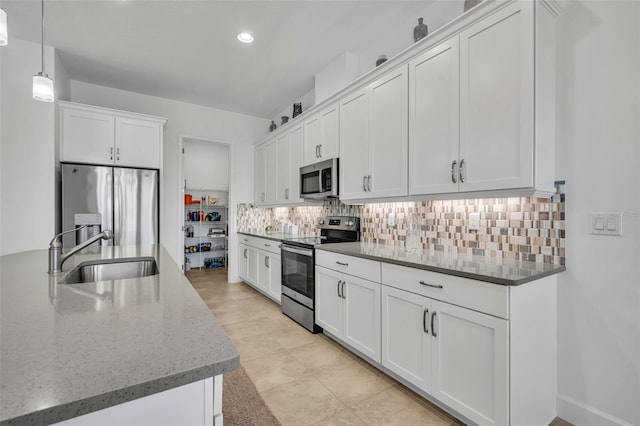 kitchen with white cabinetry, appliances with stainless steel finishes, decorative backsplash, and a sink