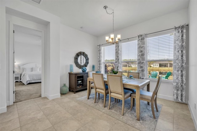 dining area featuring light tile patterned floors, baseboards, and a notable chandelier