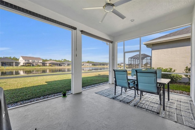 sunroom / solarium with ceiling fan, a water view, and a healthy amount of sunlight