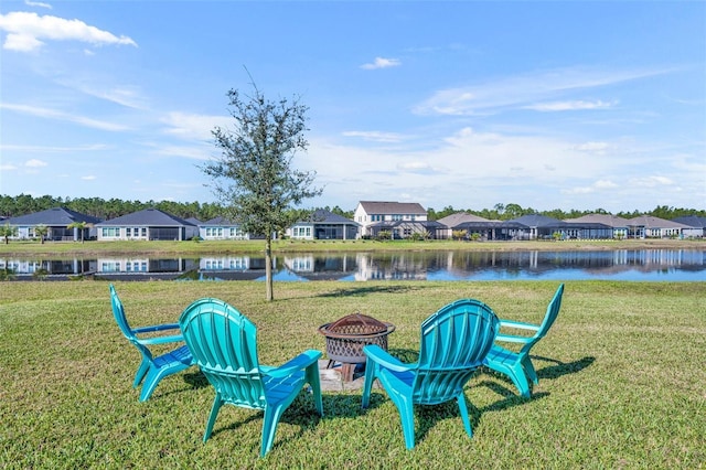 view of yard featuring a fire pit, a water view, and a residential view