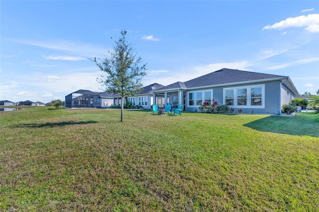 back of property featuring a lawn and stucco siding