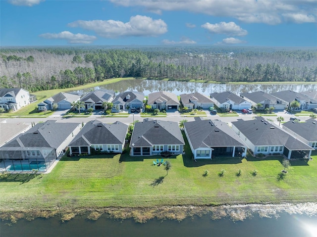 drone / aerial view featuring a water view, a forest view, and a residential view