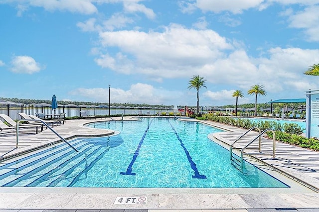 pool with a patio and fence