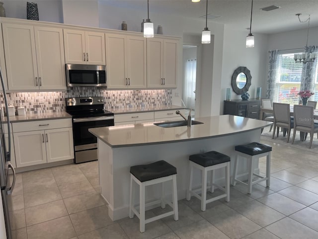 585 Mosaic Blvd, Daytona Beach, FL 32124 - kitchen featuring appliances with stainless steel finishes, a sink, decorative backsplash, light tile patterned floors, and visible vents