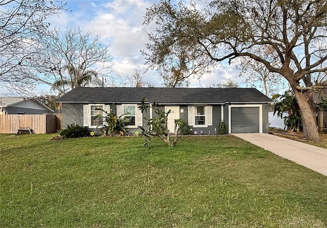 ranch-style home featuring a garage, a front yard, driveway, and stucco siding