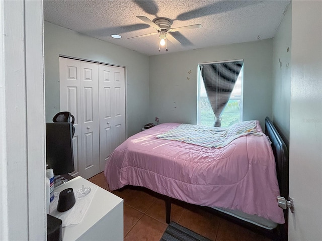 tiled bedroom featuring a ceiling fan, a closet, and a textured ceiling