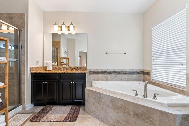 bathroom featuring a shower stall, a garden tub, vanity, and plenty of natural light