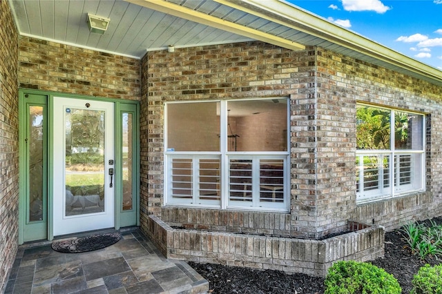 property entrance featuring brick siding