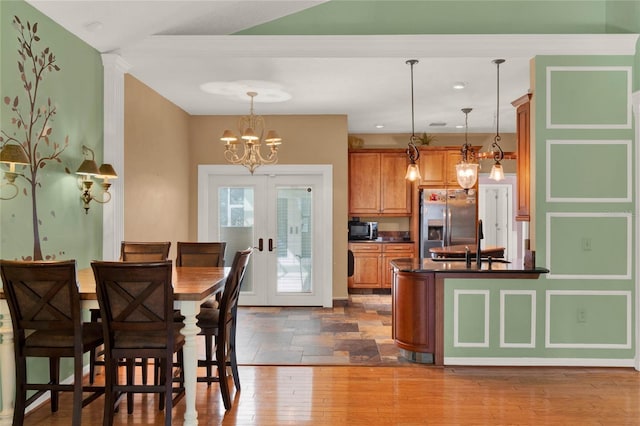 kitchen featuring french doors, brown cabinets, dark wood finished floors, stainless steel refrigerator with ice dispenser, and dark countertops