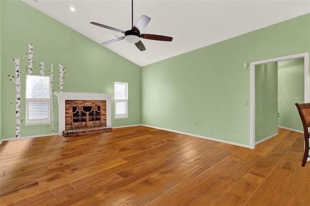 unfurnished living room featuring baseboards, ceiling fan, wood finished floors, a fireplace, and high vaulted ceiling