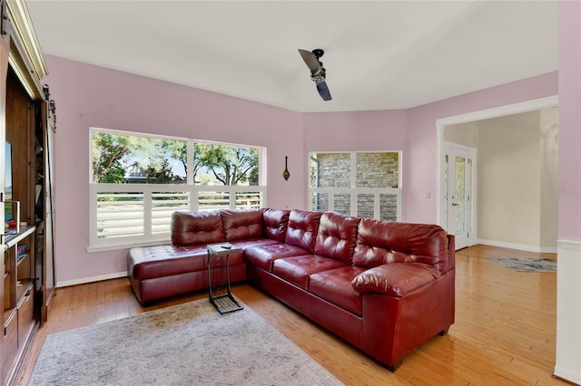 living room featuring a ceiling fan, baseboards, and hardwood / wood-style floors