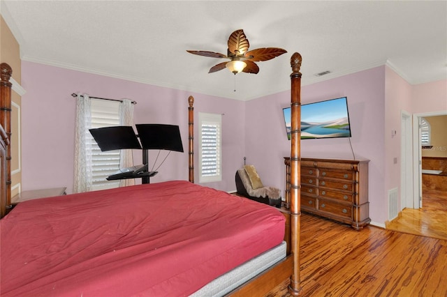 bedroom with ceiling fan, light wood-style flooring, visible vents, and crown molding