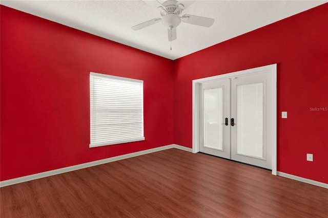 spare room featuring ceiling fan, a textured ceiling, wood finished floors, baseboards, and french doors