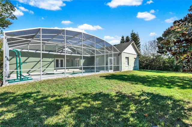 rear view of property with a yard, a patio, a lanai, and an outdoor pool