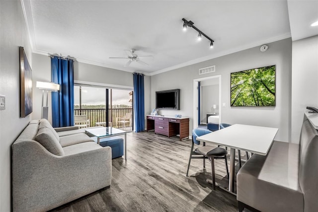 living area featuring ceiling fan, crown molding, wood finished floors, visible vents, and track lighting