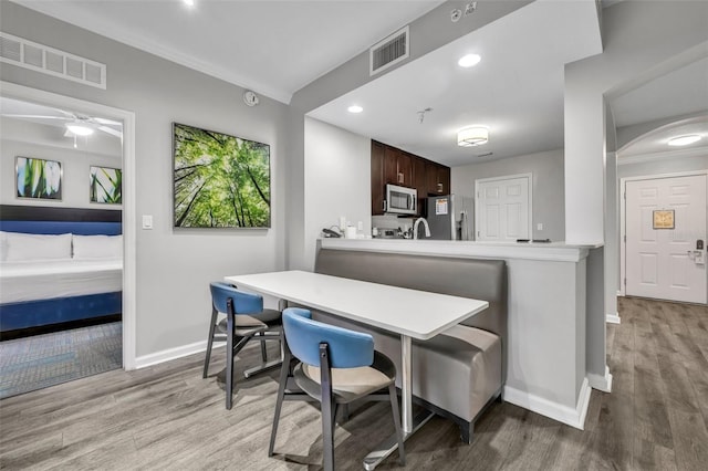 kitchen with light countertops, appliances with stainless steel finishes, visible vents, and dark brown cabinetry