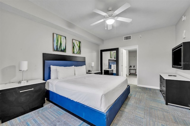 bedroom with ceiling fan, dark carpet, visible vents, and baseboards