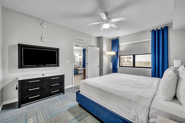 carpeted bedroom with visible vents, ceiling fan, a textured ceiling, and baseboards