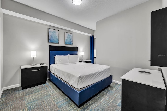 bedroom featuring a textured ceiling and baseboards