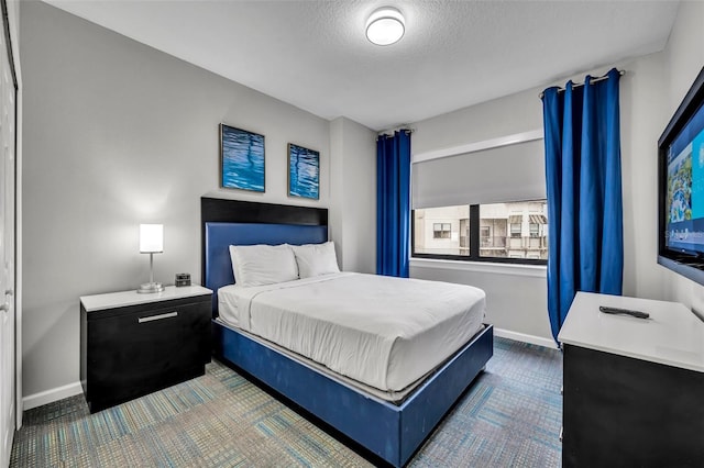 bedroom featuring baseboards, a textured ceiling, and carpet flooring