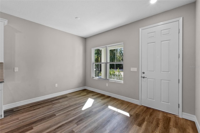 entryway featuring baseboards and wood finished floors