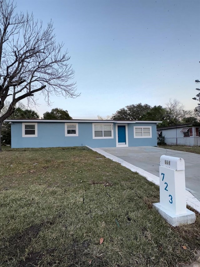 ranch-style house featuring stucco siding and a front yard