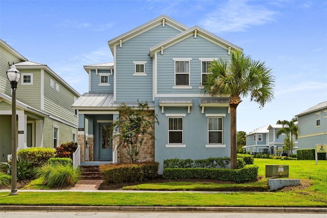 view of front of home featuring metal roof and a front yard