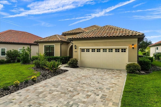 9235 San Jose Blvd, Howey In The Hills, FL 34737 - mediterranean / spanish-style home with an attached garage, decorative driveway, a front lawn, stucco siding, and a tile roof