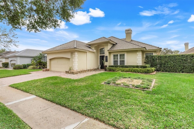 view of front of property with a garage, decorative driveway, and a front lawn