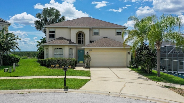 traditional-style house featuring driveway, a shingled roof, an attached garage, a front lawn, and stucco siding