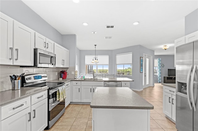 kitchen with light tile patterned floors, visible vents, backsplash, appliances with stainless steel finishes, and a sink