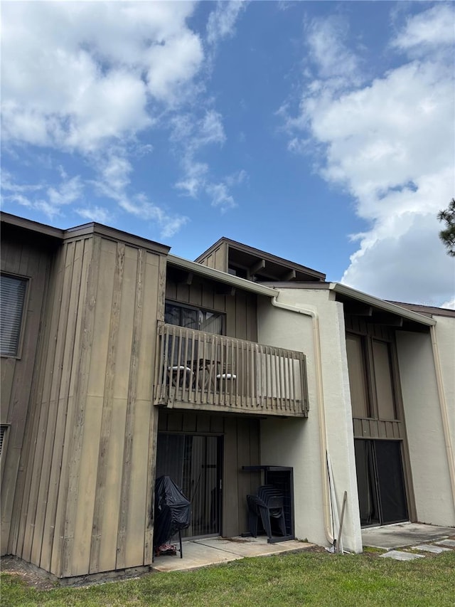 rear view of house featuring a balcony and board and batten siding