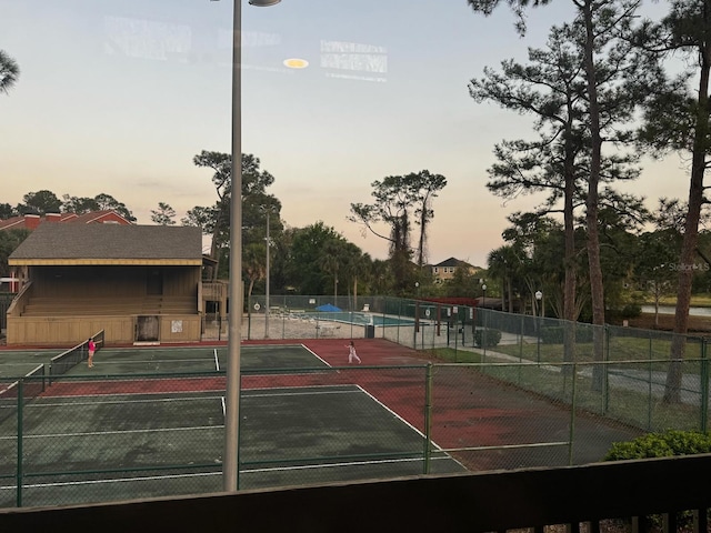 view of tennis court featuring fence