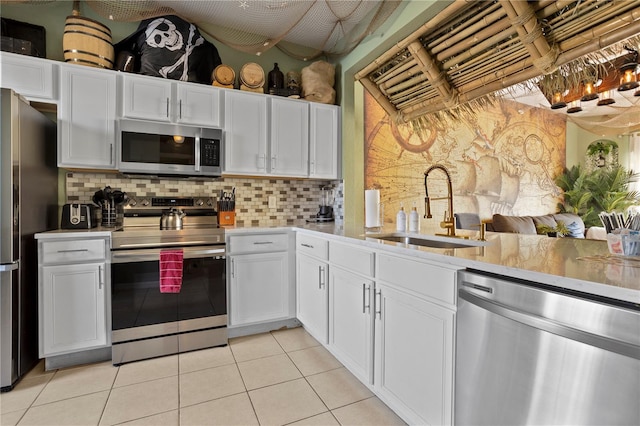 kitchen with stainless steel appliances, light countertops, a sink, and tasteful backsplash