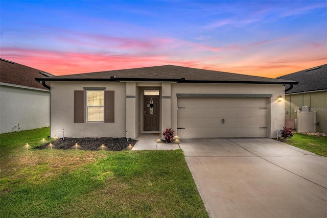 view of front of home featuring roof with shingles, stucco siding, an attached garage, a front yard, and driveway