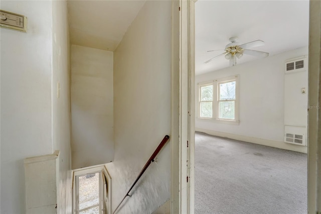 stairway featuring carpet floors, visible vents, baseboards, and a ceiling fan