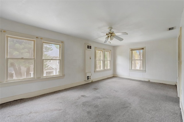 unfurnished room with light carpet, ceiling fan, visible vents, and baseboards