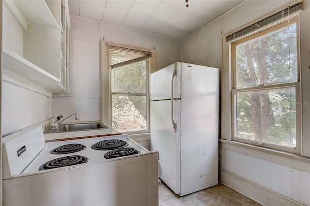 kitchen featuring light countertops, white appliances, a sink, and a wealth of natural light