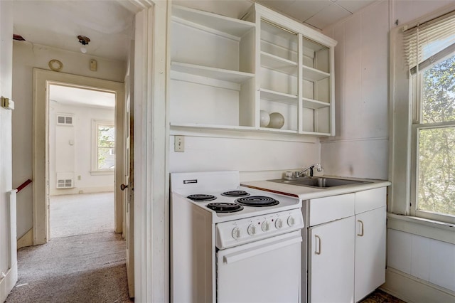 kitchen with light countertops, white electric range, carpet, and open shelves