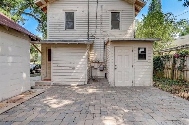 rear view of house with a patio area and fence