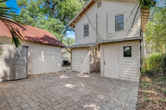 rear view of house featuring an outbuilding and a patio area