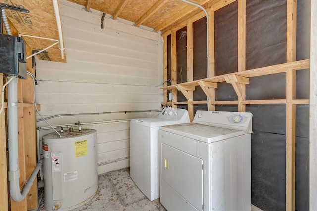 clothes washing area featuring wooden walls, washing machine and dryer, water heater, and laundry area