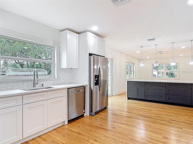 kitchen featuring visible vents, appliances with stainless steel finishes, light countertops, and a sink