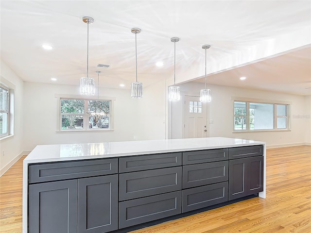 kitchen featuring gray cabinets, light countertops, visible vents, light wood-type flooring, and baseboards