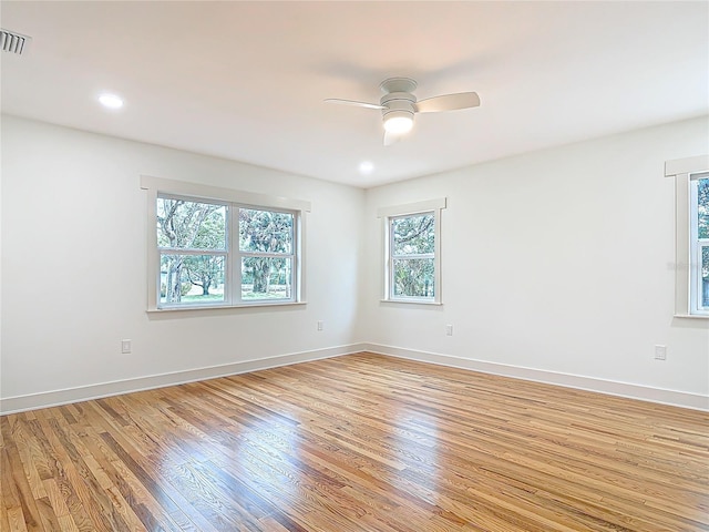 spare room featuring light wood finished floors, visible vents, baseboards, and a ceiling fan