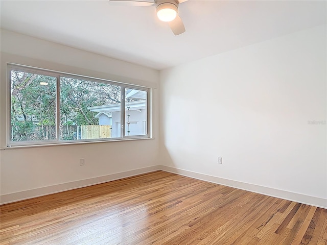 unfurnished room with light wood-style flooring, baseboards, and a ceiling fan