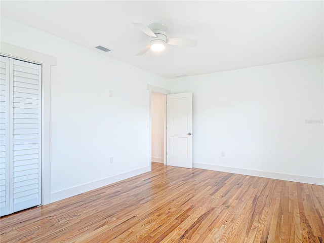 interior space with a ceiling fan, light wood-type flooring, visible vents, and baseboards